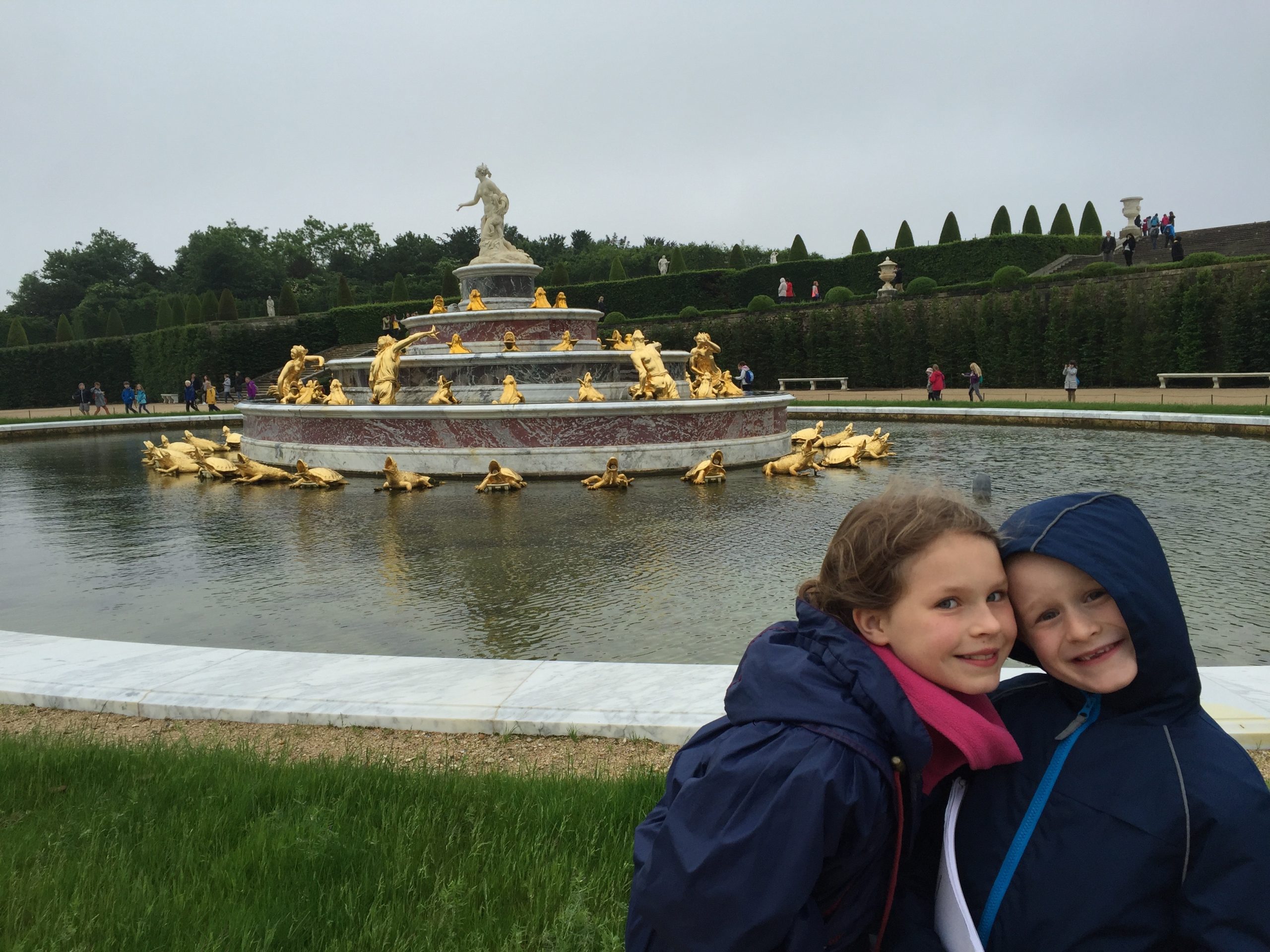 Photo of two young children in front of a fountain