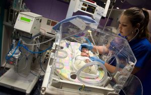Nurse leaning over an infant