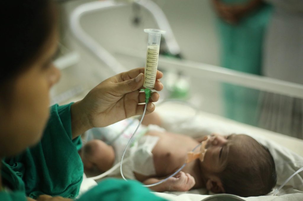 Nurse tube feeding infant