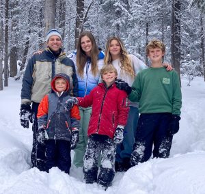 Family standing together in a snowy forest